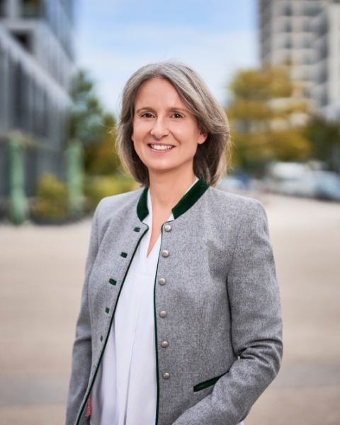 Porträt von Katerina Rogers im Trachtenlook vor moderner Gebäudekulisse in München
