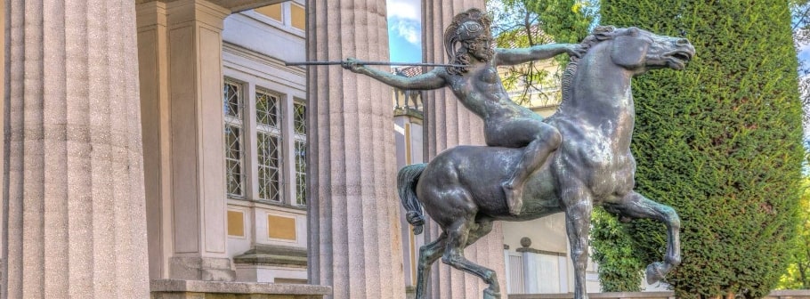 Bronzene Reiterstatue vor klassizistischer Säulenfassade in München, historisches Wahrzeichen der Stadt