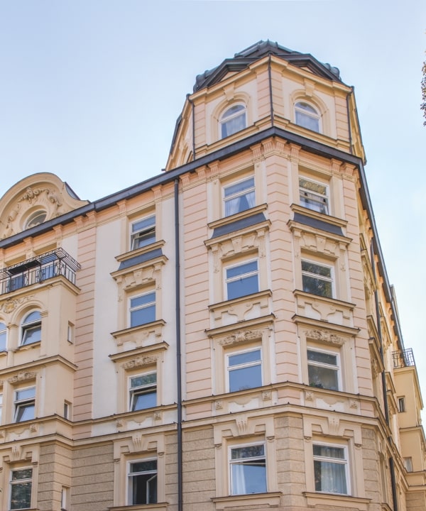 Historische Eckfassade mit rundem Erkerturm, Stuckverzierungen und mehreren Fensterreihen in München.