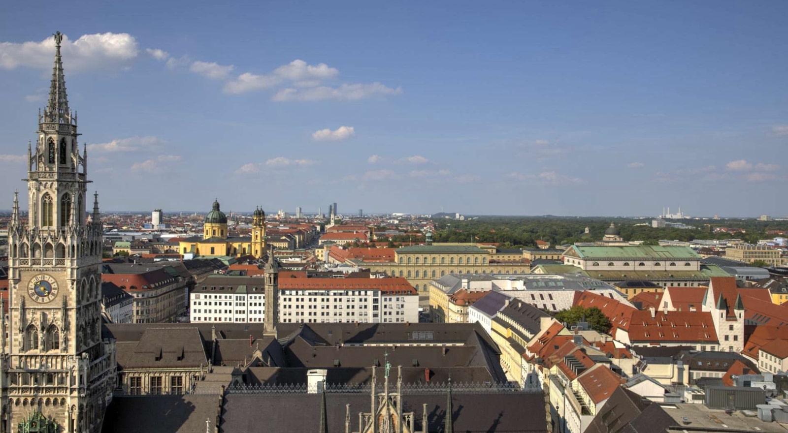 Blick über die Dächer Münchens mit dem Turm des Neuen Rathauses am Marienplatz vor blauem Himmel