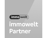 Graues Siegel mit Immowelt-Logo und Schriftzug 'immowelt Partner' als Auszeichnung.