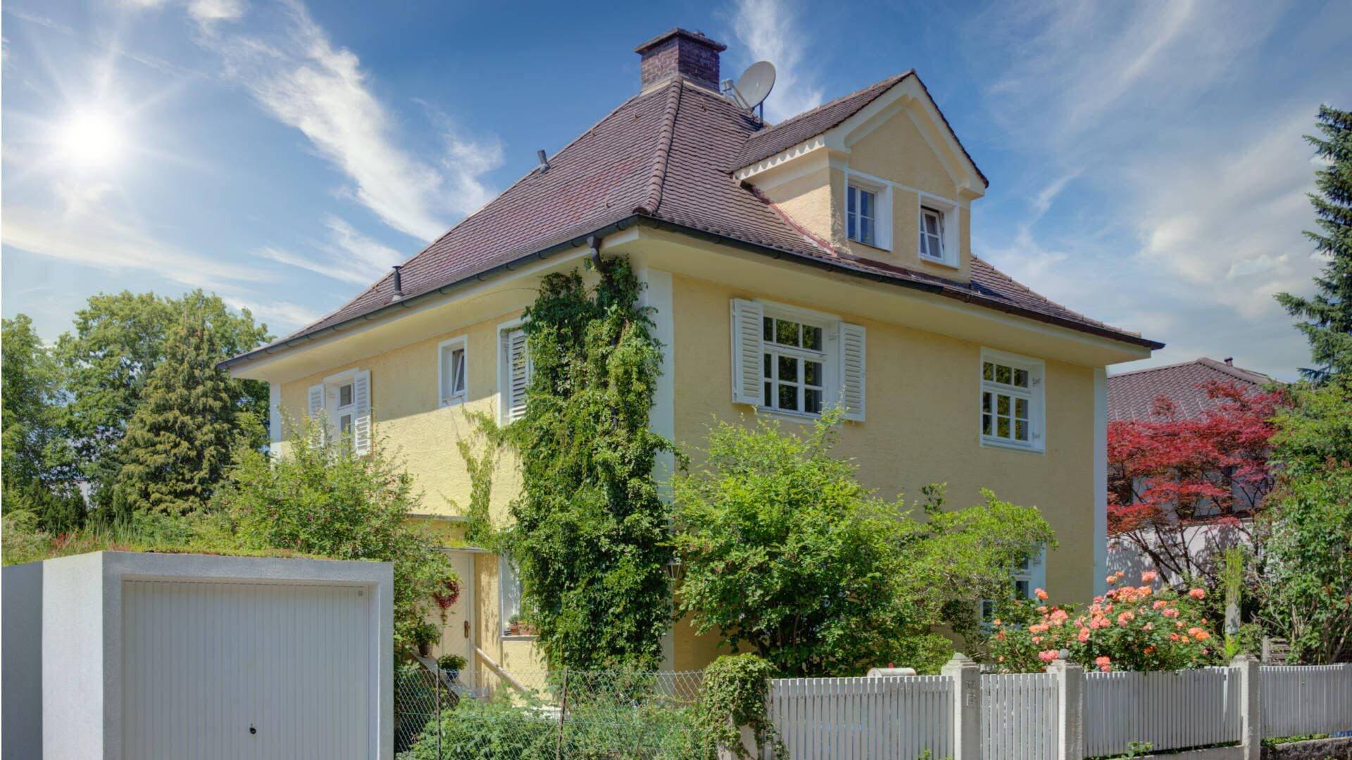 Gelbes Einfamilienhaus mit Garten als Symbolbild für den Verkauf einer geerbten Immobilie
