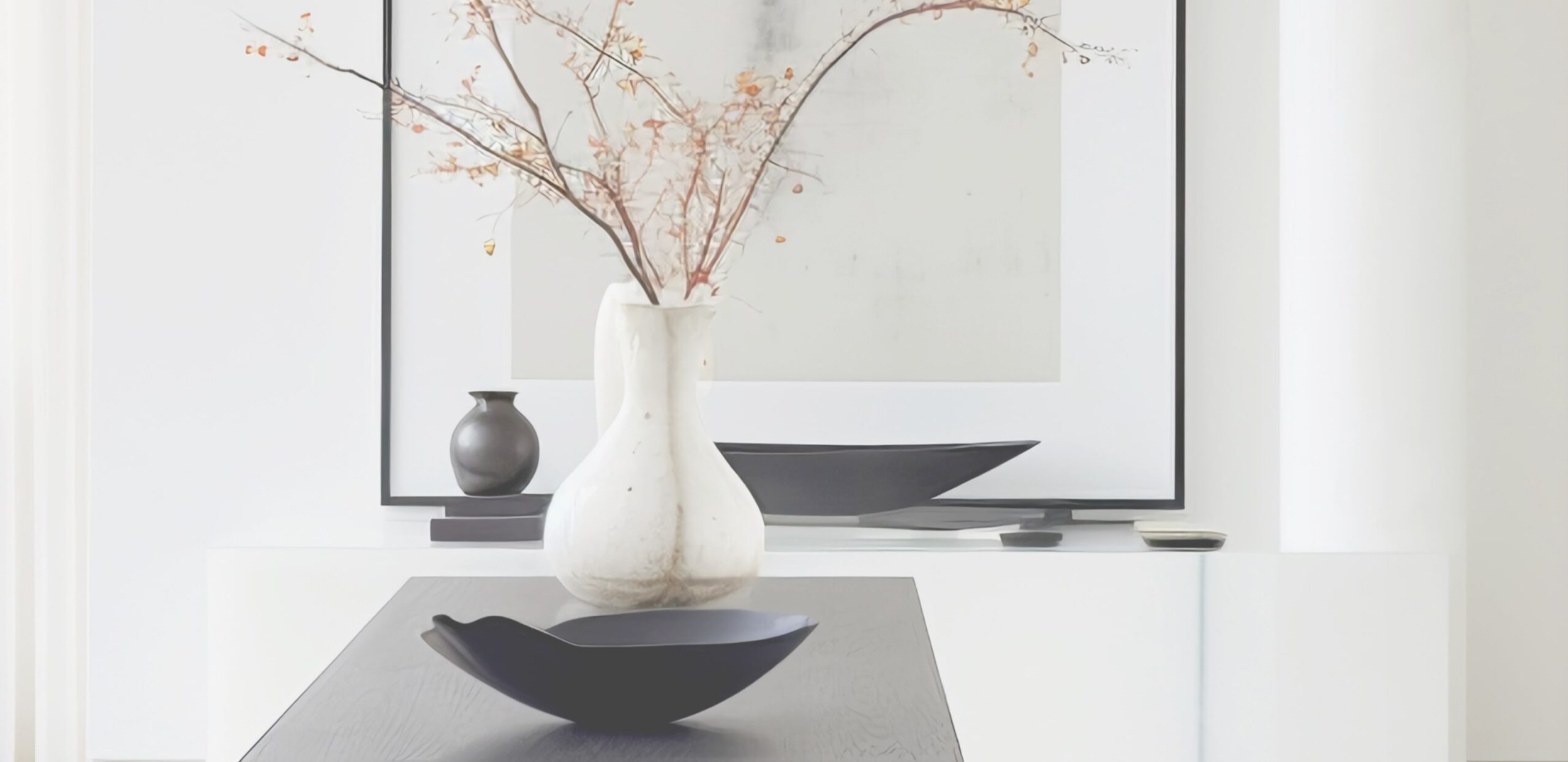Modern gestalteter kleiner Eingangsbereich mit weißer Vase und dunklen Schalen als Deko