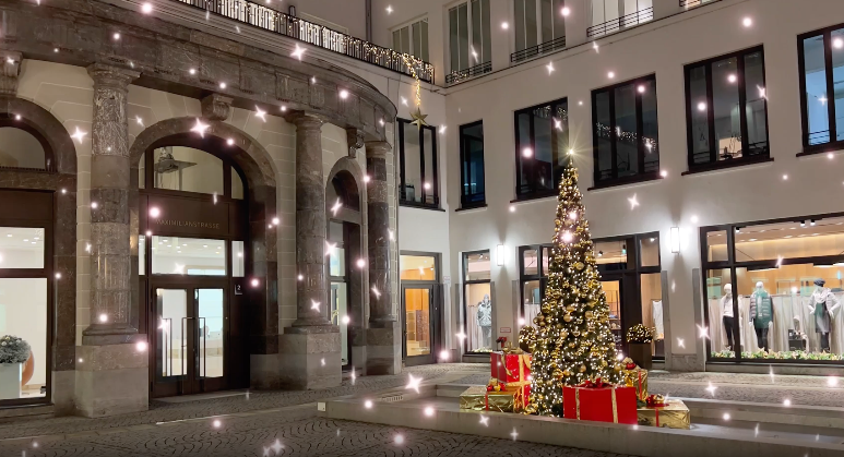 Festlich beleuchteter Innenhof mit Weihnachtsbaum und Geschenken in der Münchner Innenstadt bei Nacht