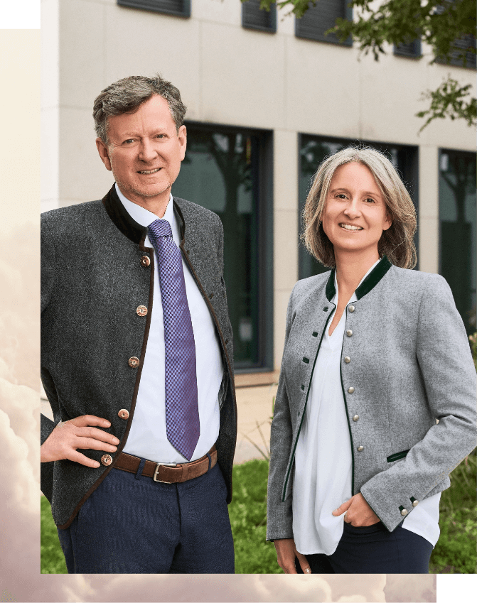 Geschäftsführerpaar von Rogers Immobilien lächelt gemeinsam vor dem Firmengebäude