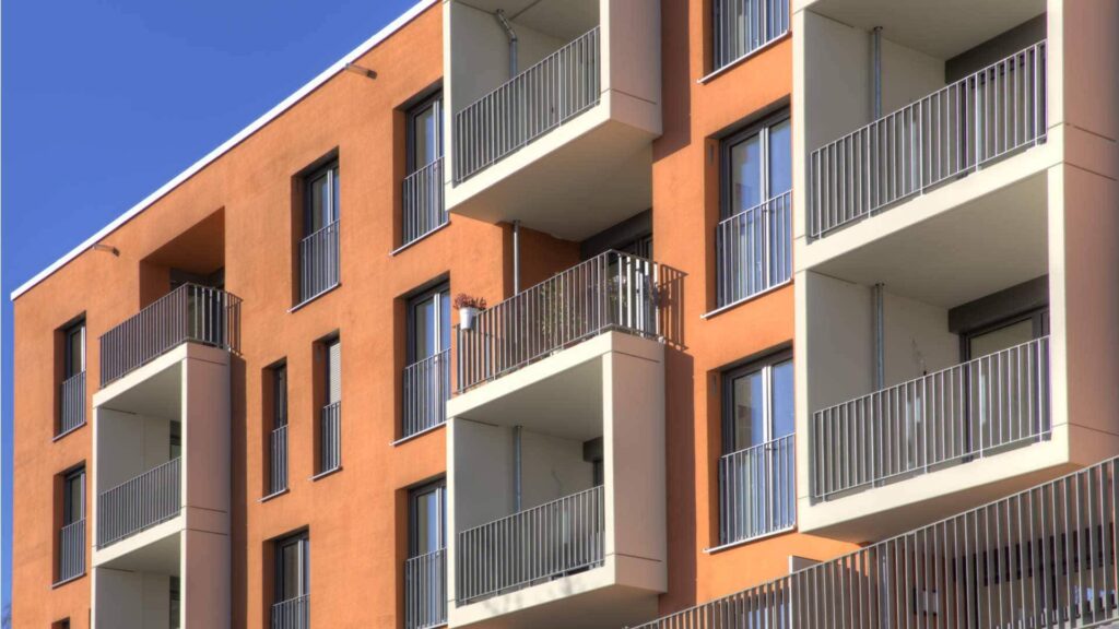 Moderner Neubau mit ziegelroter Fassade und zahlreichen Balkonen