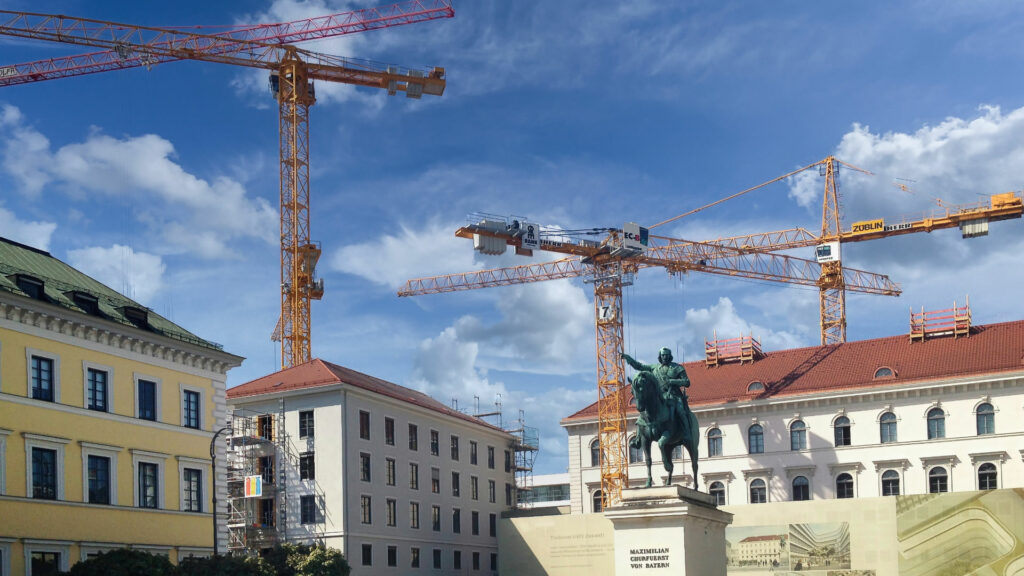 Baukräne über historischen Gebäuden am Wittelsbacherplatz in München mit Reiterstandbild