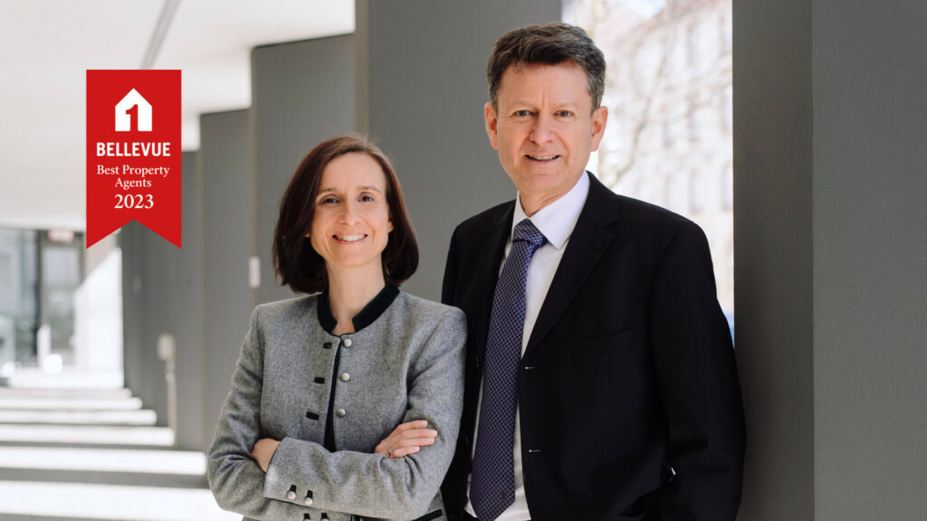 Zwei Immobilienexperten mit der Auszeichnung Bellevue Best Property Agents 2023 in modernem Ambiente