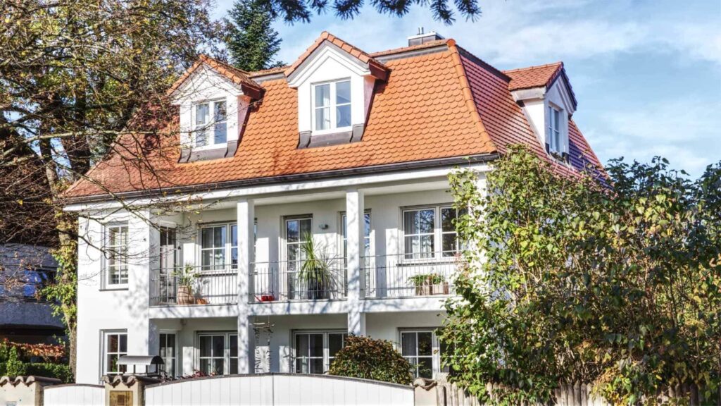 Weiße klassizistische Villa mit Säulen, Balkonen und rotem Ziegeldach