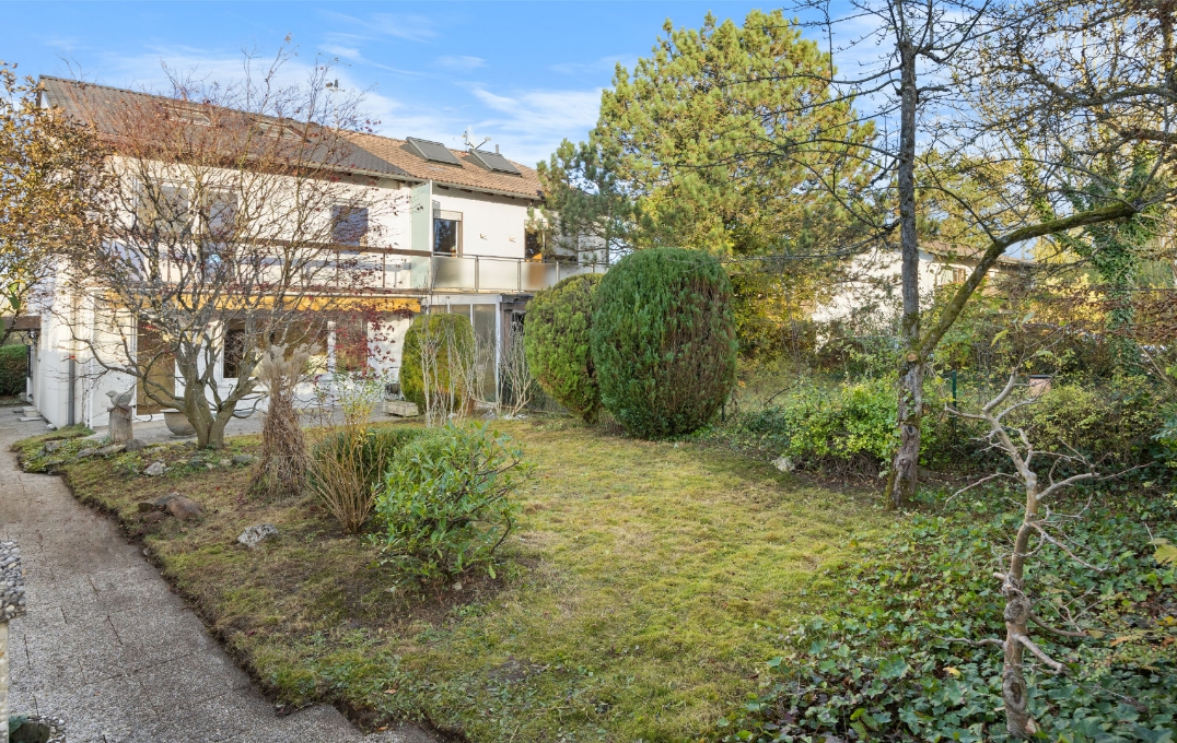 Hausrückseite mit gepflegtem Garten und Gartenweg in Gauting im Herbst