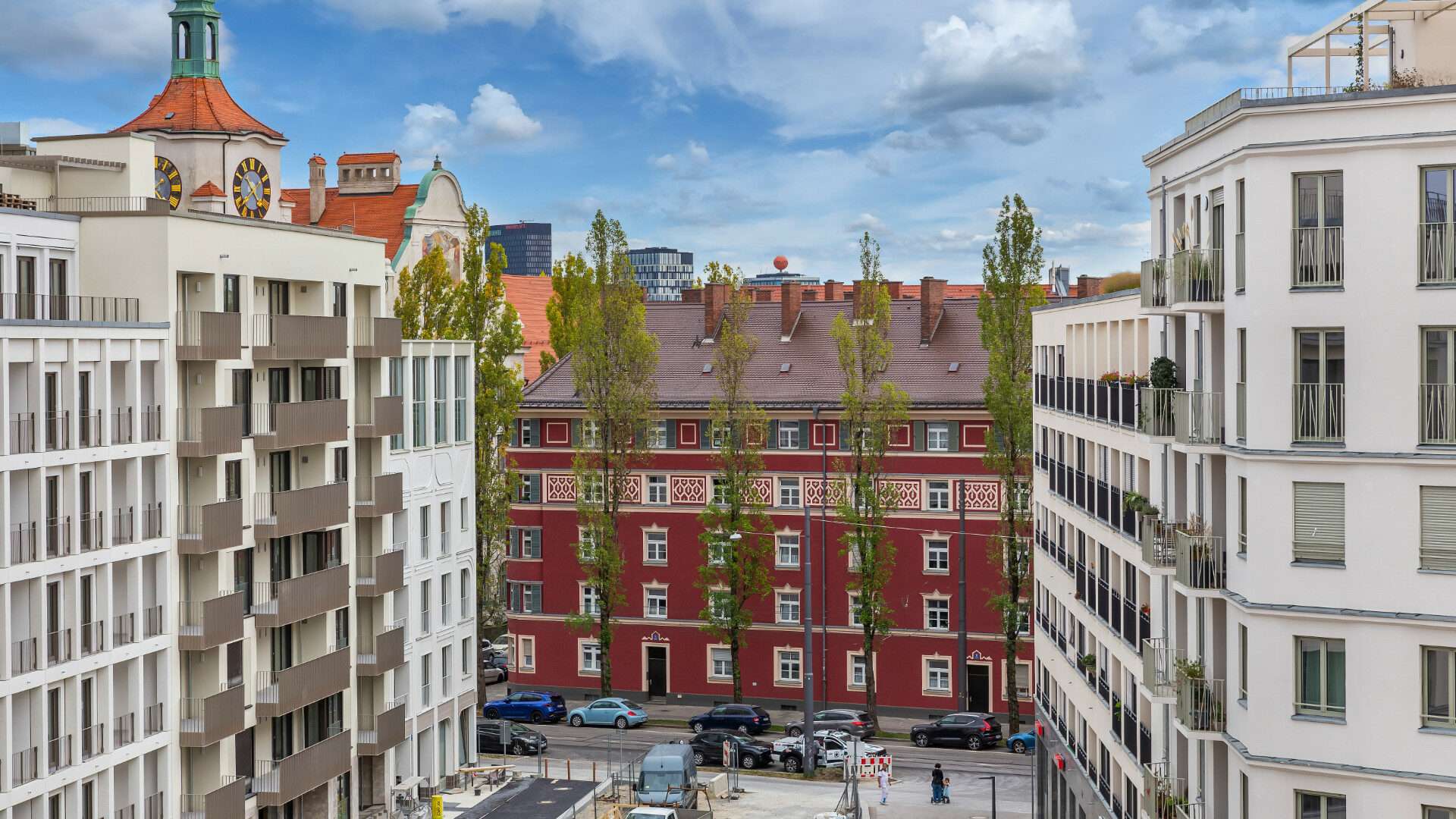 Roter Altbau zwischen modernen weißen Neubaufassaden im Münchner Stadtteil Haidhausen