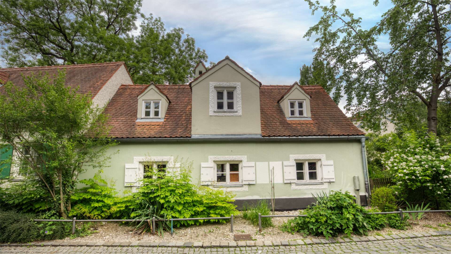 Kleines cremefarbenes Landhaus mit Fensterläden und Garten an der Preysingstraße in München-Haidhausen