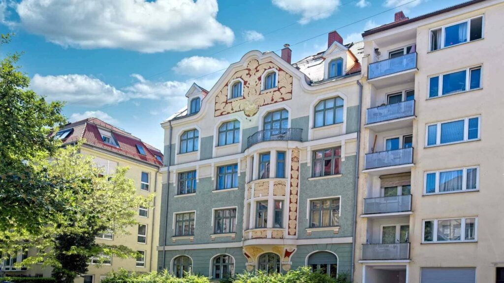 Kunstvoll verzierte Jugendstilfassade eines Wohnhauses in grün-cremefarbenen Tönen