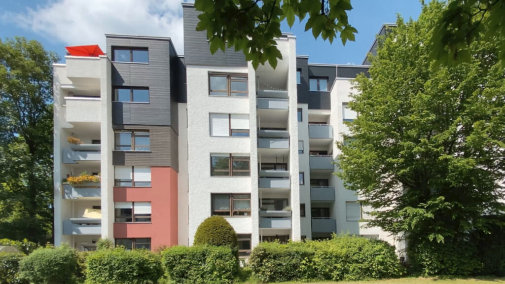 Mehrstöckiges Wohngebäude mit Balkonen und Grünanlage, betreut von einer Hausverwaltung