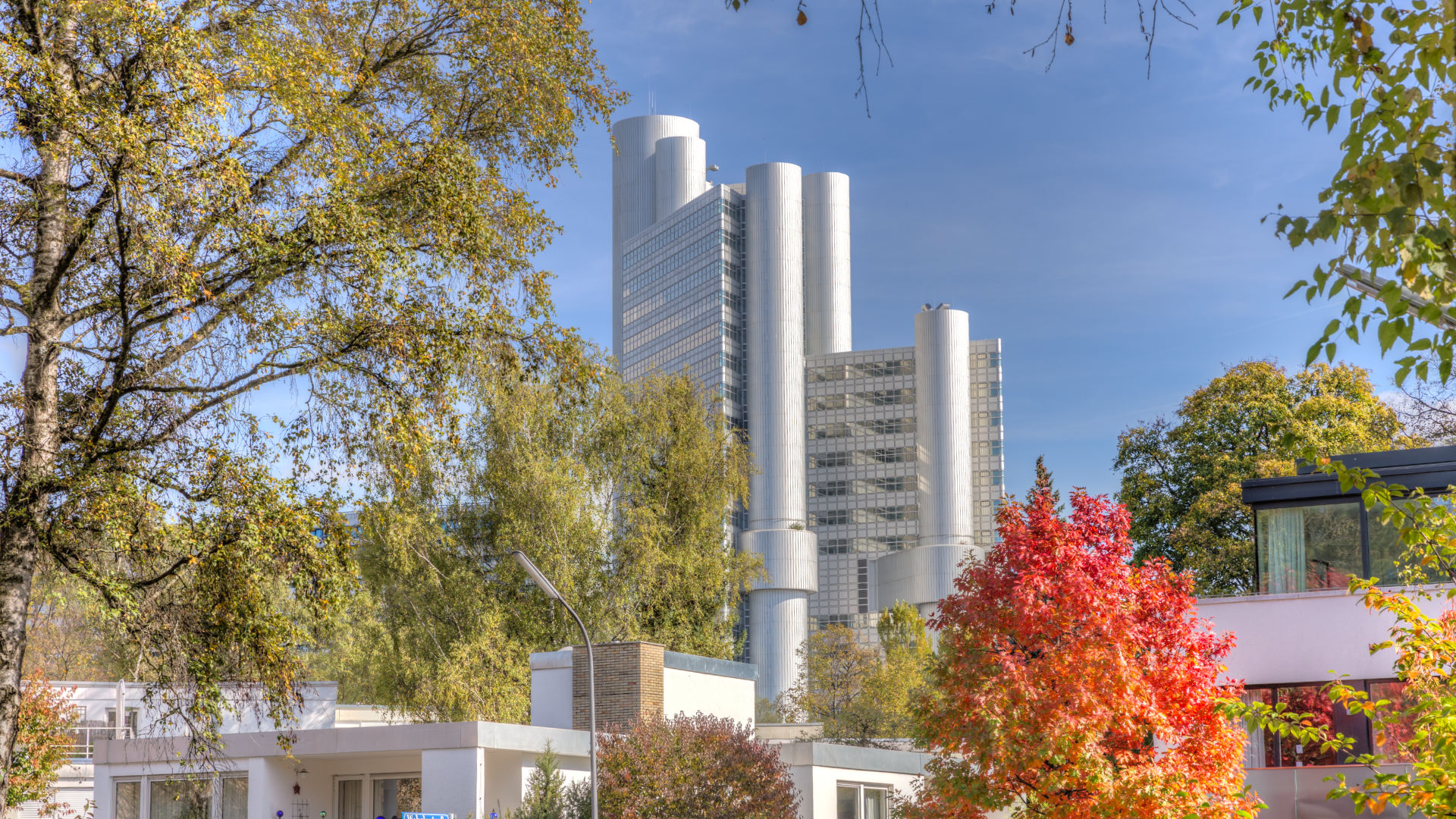 Hochhaustürme der HypoVereinsbank hinter herbstlich gefärbten Bäumen in München
