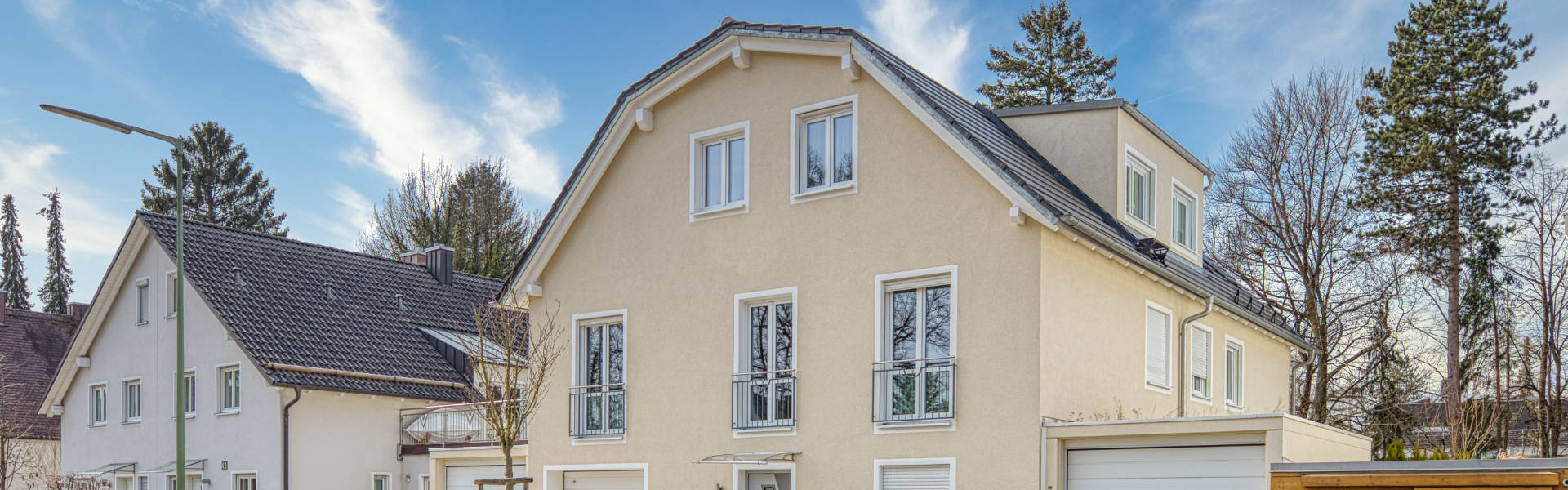 Beiges Wohnhaus mit Satteldach und Garage im Münchner Stadtteil Forstenried – Symbolbild zum Immobilienmakler