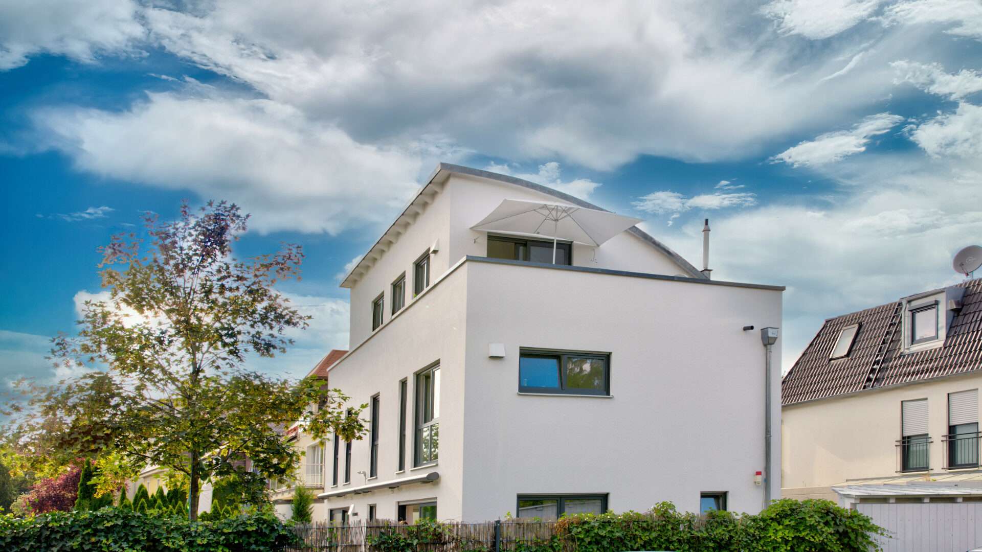 Modernes weißes Einfamilienhaus mit rundem Erker im Münchner Stadtteil Laim
