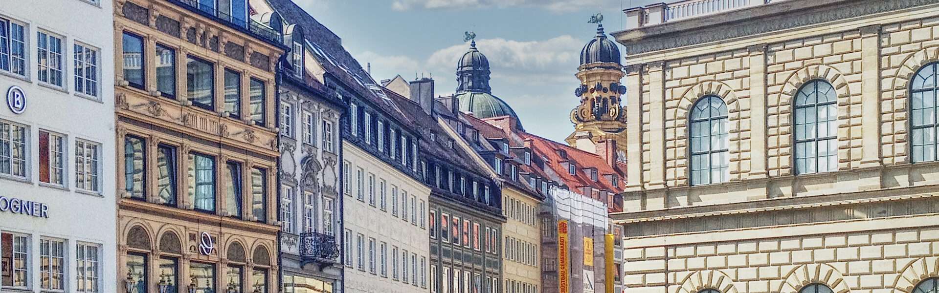Historische Altstadtfassaden mit Kirchtürmen im Hintergrund im Münchner Stadtteil Lehel