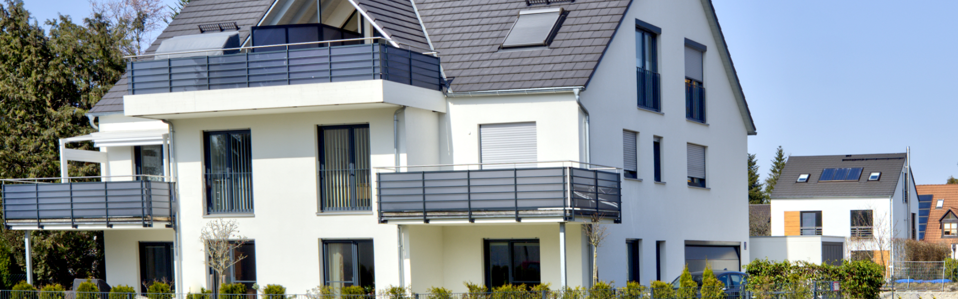 Weißer Neubau mit Balkonen und Dachterrasse im Münchner Stadtteil Milbertshofen