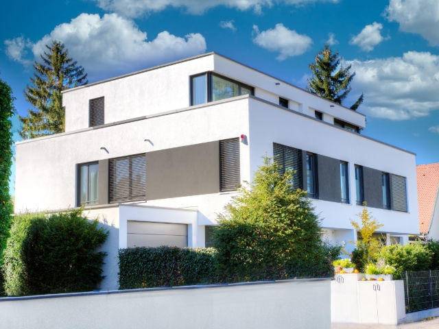 Modernes weißes Architektenhaus mit Flachdach und großen Fenstern – Symbolbild zu Immobilienpreisen in Thalkirchen
