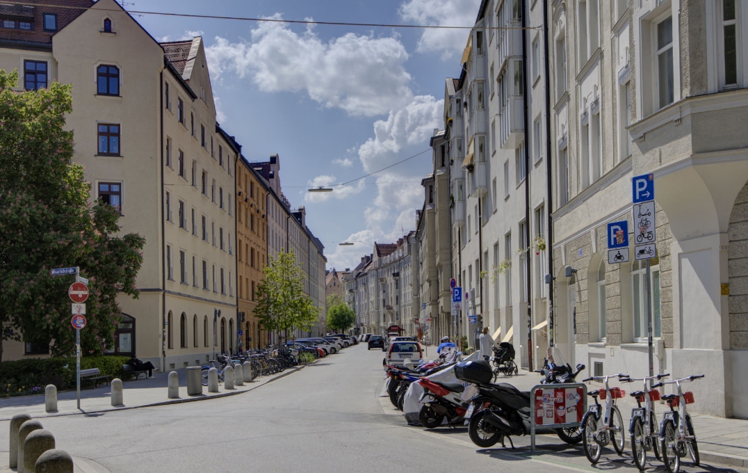 Straße in der Isarvorstadt mit bunten Altbaufassaden und geparkten Fahrrädern in München