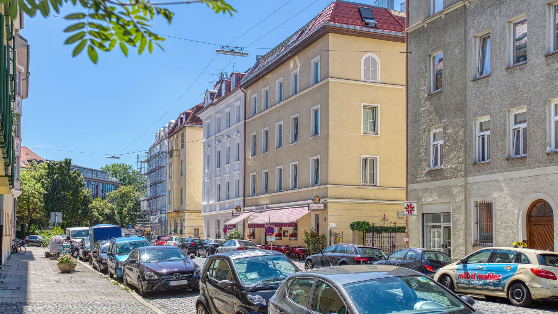 Wohnstraße mit historischen Fassaden und parkenden Autos im Münchner Stadtteil Neuhausen