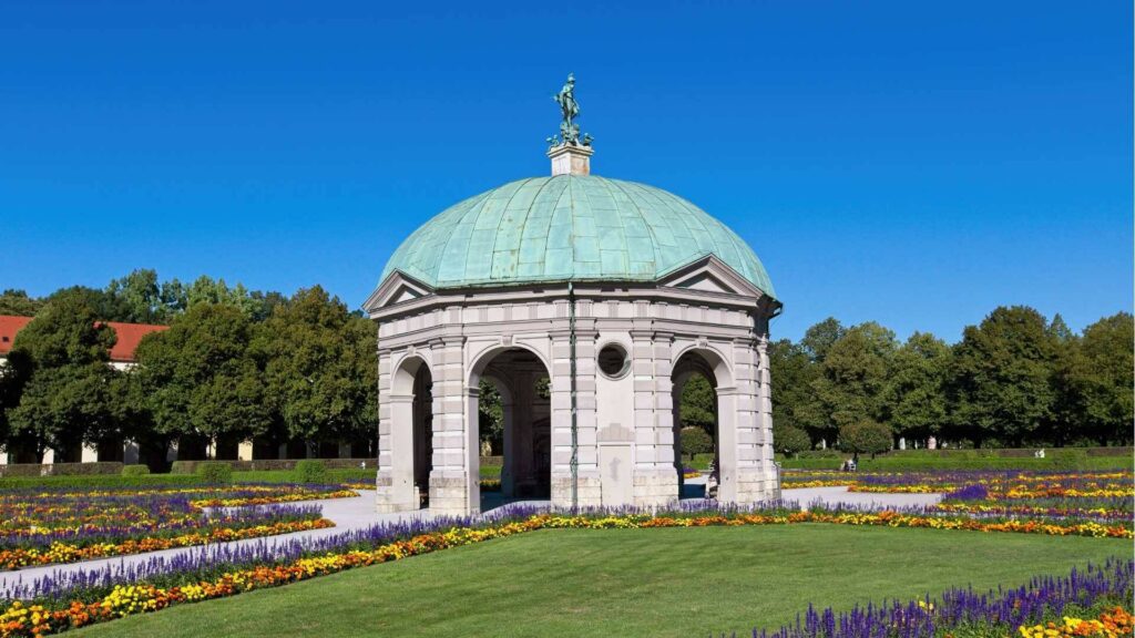 Dianatempel im Münchner Hofgarten umgeben von bunten Blumenbeeten im Sommer
