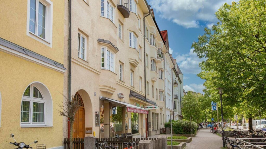 Gelbe Altbau-Häuserzeile mit Fahrrädern an einer Straße in München-Sendling