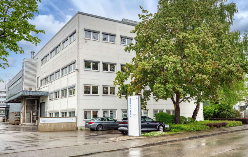 Bürogebäude mit Parkplatz und Bäumen in Puchheim bei Regenwetter