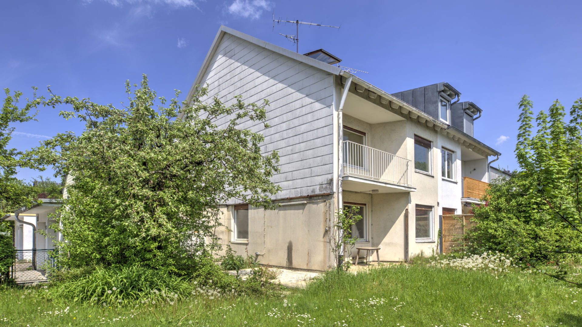 Renovierungsbedürftiges Einfamilienhaus mit zugewachsenem Garten in München