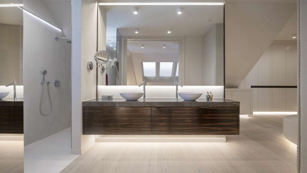 Modernes Badezimmer mit dunklem Doppelwaschtisch und indirekter Beleuchtung in einer Villa in Regensburg