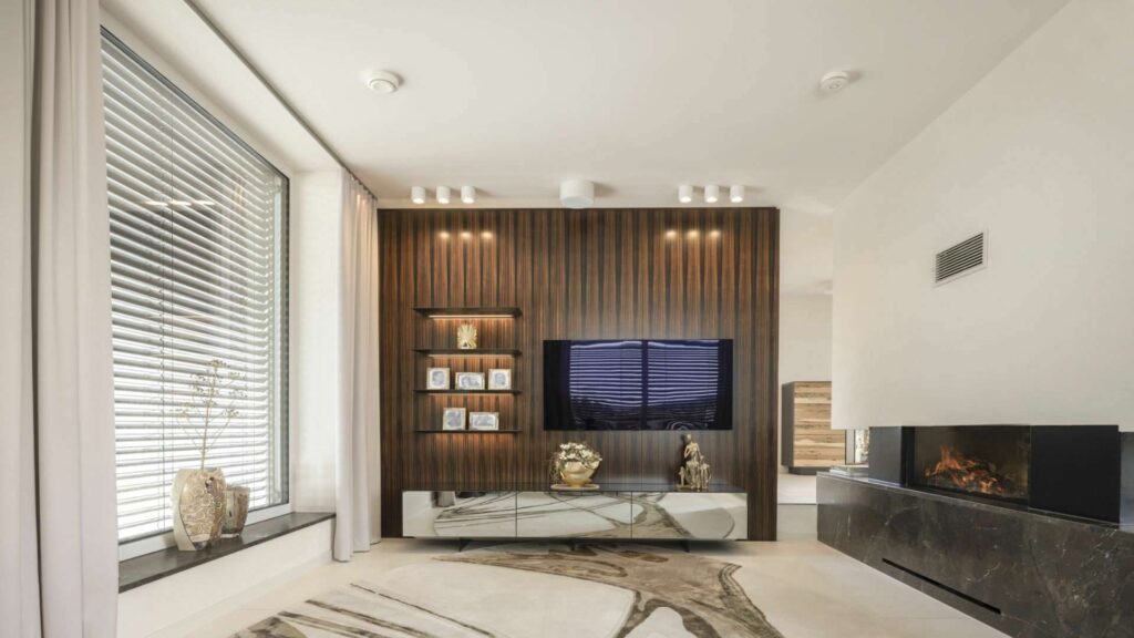Eleganter Wohnbereich mit Kamin, Holzverkleidung und großer Fensterfront in einer Villa in Regensburg
