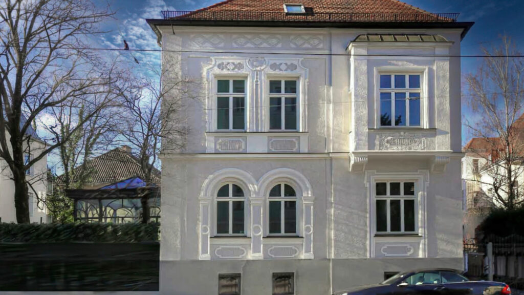 Saniertes historisches Wohnhaus mit weißer Stuckfassade und Walmdach