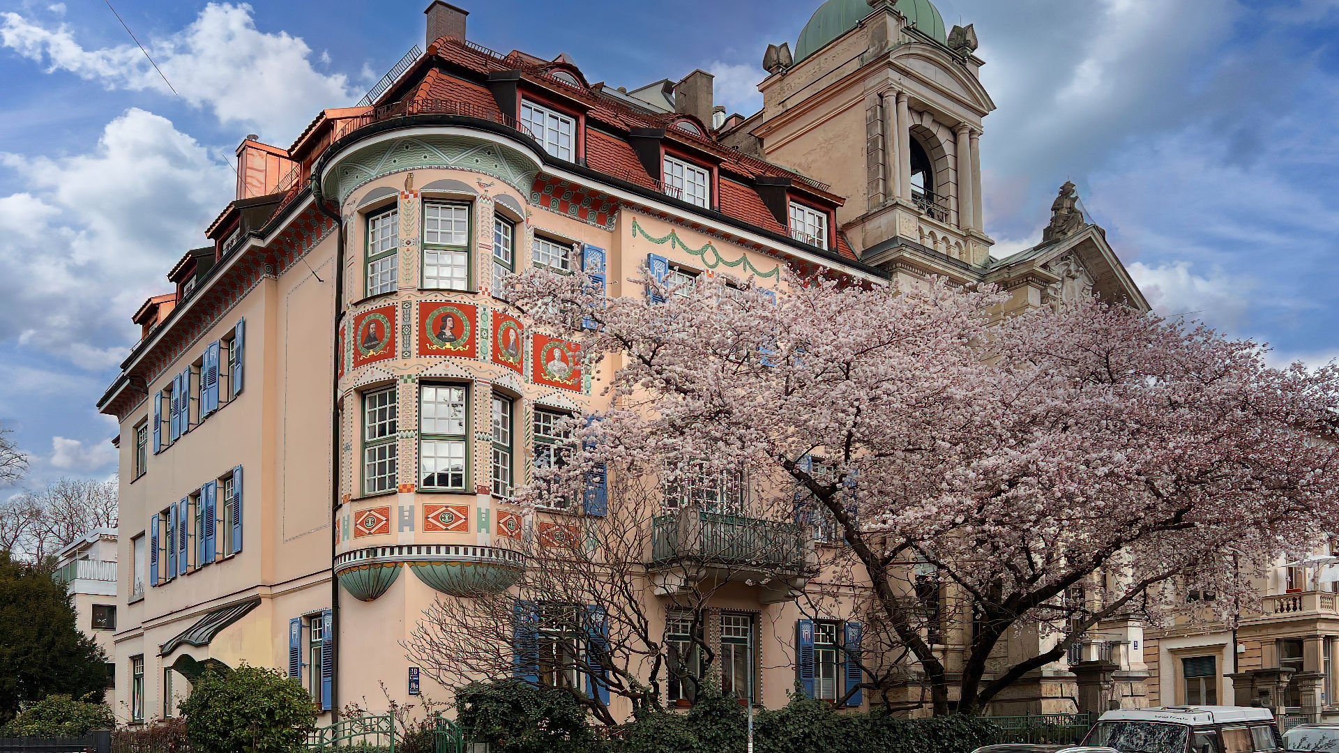 Repräsentativer Altbau mit Türmchen und blühendem Kirschbaum im Münchner Stadtteil Schwabing