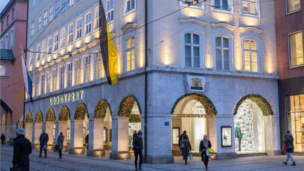 Beleuchtete Einkaufspassage mit Arkaden in der Münchner Innenstadt bei Abenddämmerung