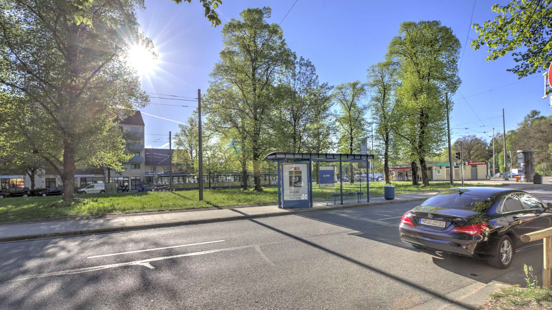 Straßenszene mit parkendem Auto und Bäumen an der Schwanseestraße im Münchner Stadtteil Giesing