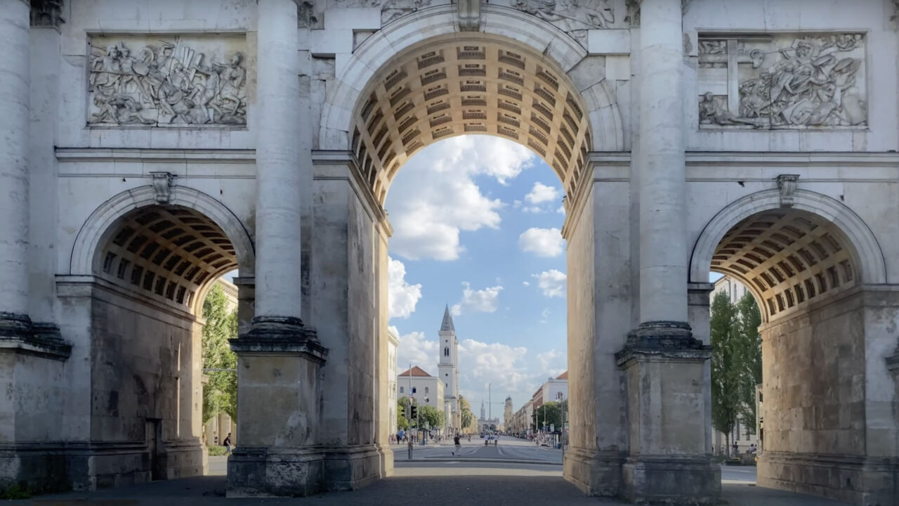 Blick durch die Torbögen des Siegestors auf die Leopoldstraße im Münchner Stadtteil Schwabing