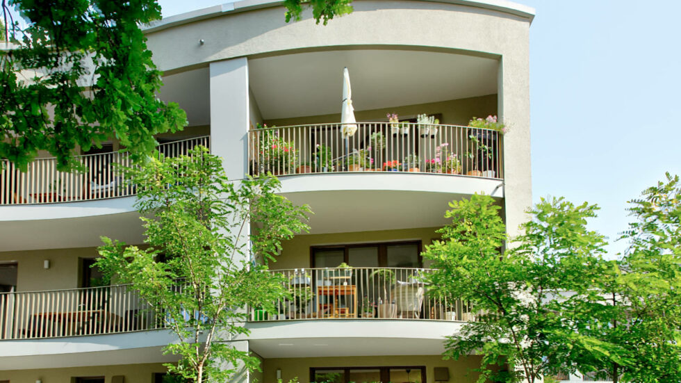 Rundbalkone eines Mehrfamilienhauses mit Bepflanzung und Sonnenschirm