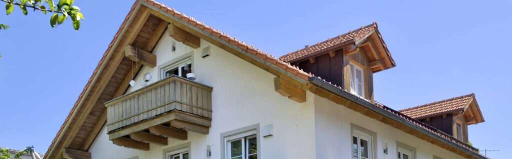 Giebel mit hölzernem Balkon eines bayerischen Wohnhauses in München-Aubing