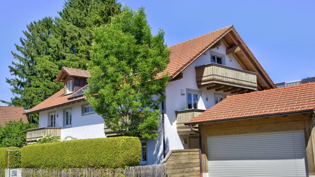 Außenansicht eines Einfamilienhauses mit Satteldach, Balkon und Garage in München-Aubing