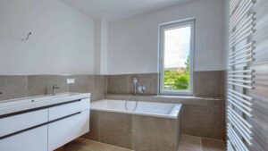 Badezimmer mit eingebauter Badewanne, Fenster und Waschtisch im Obergeschoss einer Doppelhaushälfte in Bogenhausen