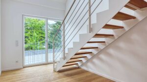 Moderne offene Treppe mit Edelstahlgeländer neben einer Terrassentür in einer Doppelhaushälfte in Bogenhausen