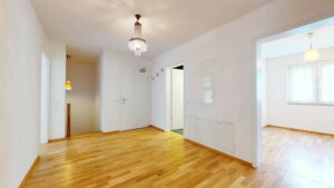 Lichtdurchflutete Diele mit Parkettboden und mehreren Zimmertüren in einer Wohnung in Bogenhausen