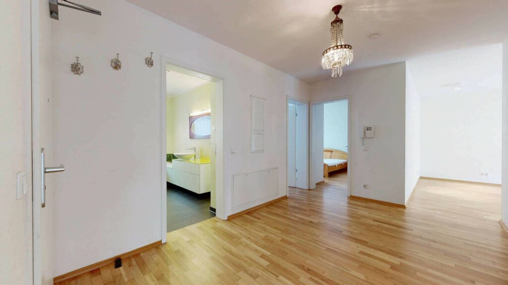 Heller Flur mit Parkettboden und Blick in mehrere Zimmer einer Wohnung in Bogenhausen
