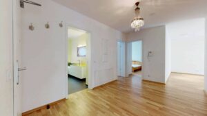 Heller Flur mit Parkettboden und Blick in mehrere Zimmer einer Wohnung in Bogenhausen