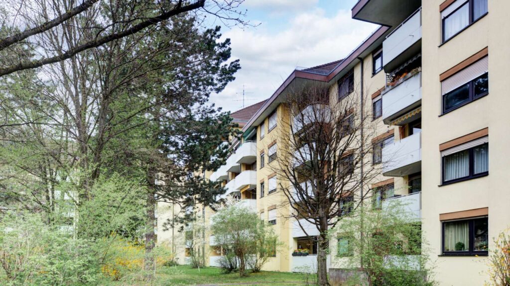Exterior view of the residential building in Munich-Bogenhausen with facade and old trees in front of the house