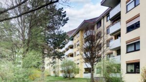 Exterior view of the residential building in Munich-Bogenhausen with facade and old trees in front of the house
