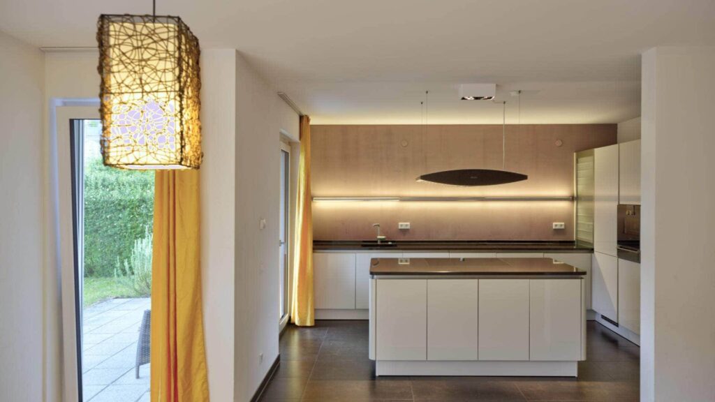 Moderne offene Küche mit Kochinsel, Holzfront und dunklem Boden in einer Wohnung in Bogenhausen