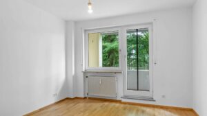 Empty bedroom with balcony door and parquet flooring in an apartment in Bogenhausen