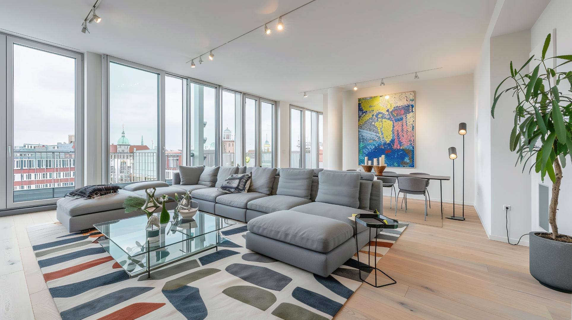 Modern eingerichtetes Wohnzimmer einer Loftwohnung mit grauem Sofa und Stadtblick